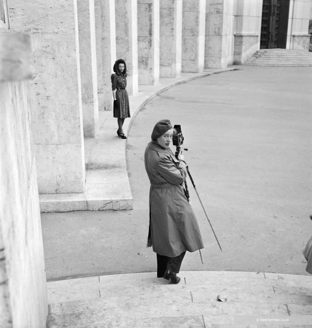 Lee Miller avec son appareil lors d’une séance photo pour Schiaparelli, Musée d’Art Moderne de Paris (MAM), Palais de Tokyo, Paris 1945 par un photographe inconnu avec Lee Miller (© Lee Miller Archives England 2026 All Rights Reserved)