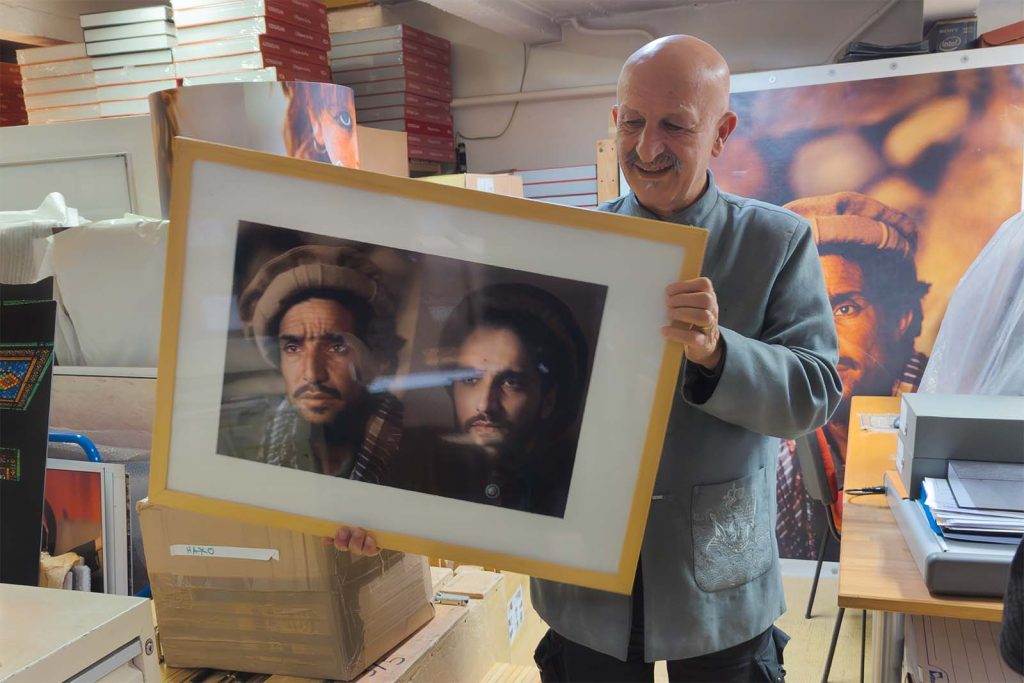 Reza dans son atelier à Paris montrant des portraits du commandant Massoud qu'il a réalisés © Stéphan Norsic